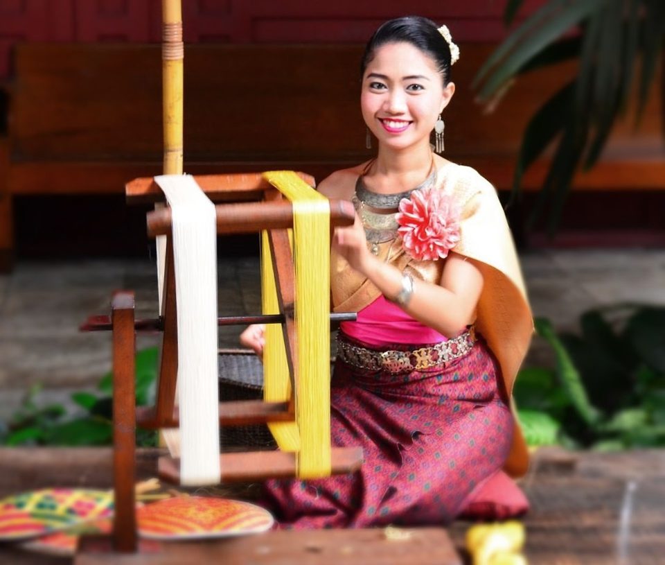 A Thai girl working on silk, THAILAND