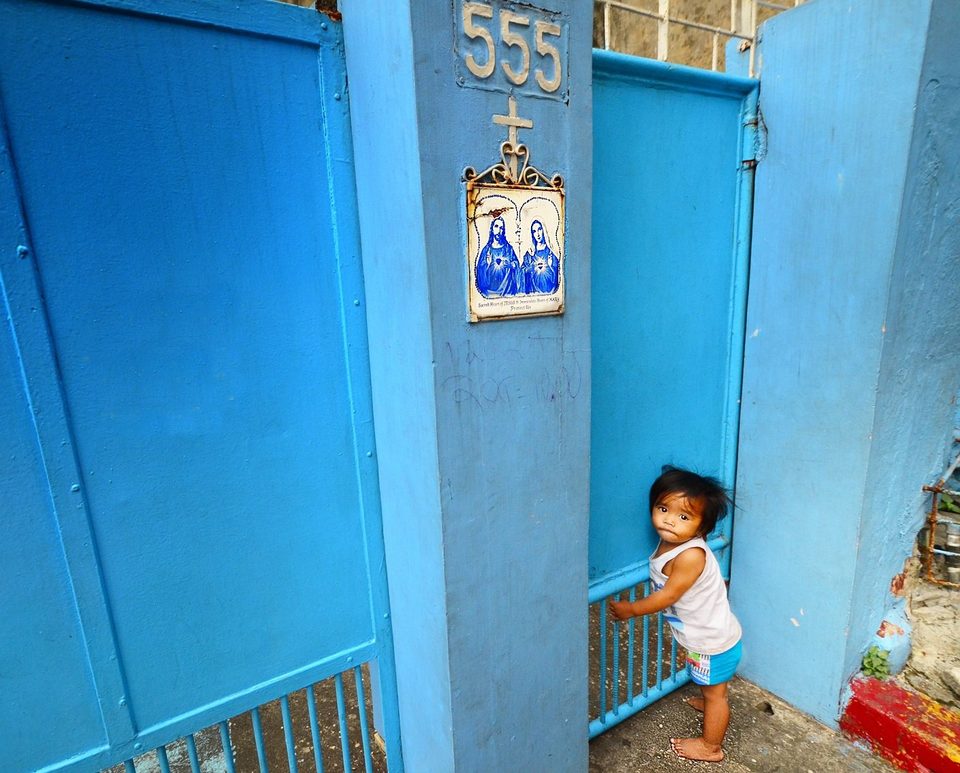 Homeless child at the back of church gate, Manila